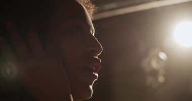 Stüdyoda çalışırken gülümseyen ve şarkı söyleyen siyahi bir kadın.