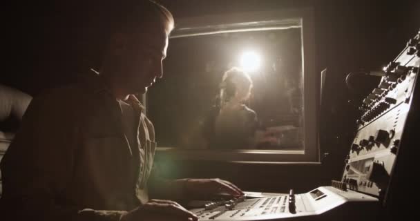 Pria Menggunakan Konsol Pencampuran Sementara Wanita Kulit Hitam Bernyanyi Studio — Stok Video