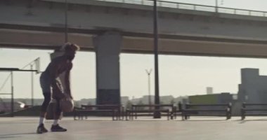 Afrika kökenli Amerikalı sporcunun gündüz vakti sahada basketbol oynarken ring kenarında serbest stil numaraları yaptığını düşünün.