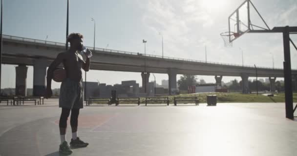 Handheld Shot Shirtless African American Sportsman Ball Sipping Fresh Water — Stock Video