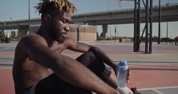 Pan Handheld Shot Tired African American Sportsman Bottle Water Sitting — Stock Video