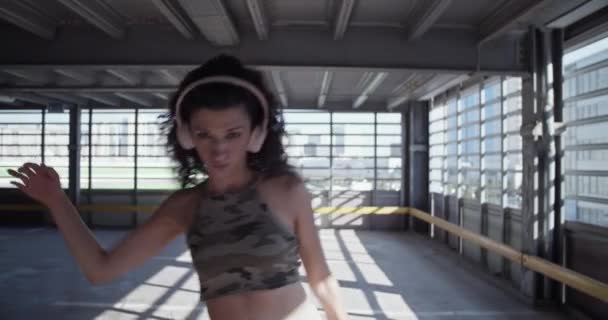 Kablosuz Kulaklıklı Genç Bayan Dansçı Kollarını Hareket Ettirmeye Geniş Otoparktaki — Stok video