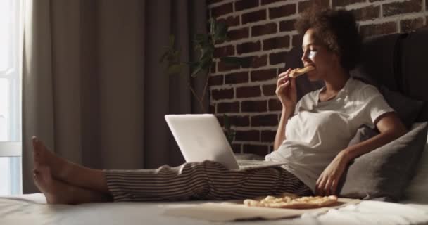 リラックスした女性食べるピザと見る映画にホーム — ストック動画