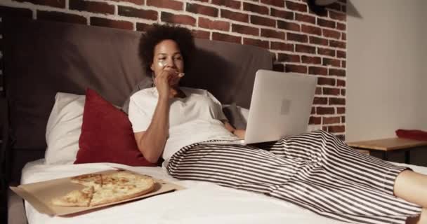 Afroamerykanka Śpioszkach Jedząca Pyszną Pizzę Oglądająca Film Laptopie — Wideo stockowe