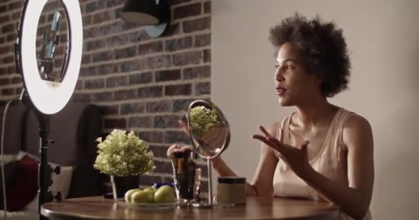 Krem Losyon Kullanan Neşeli Siyahi Kadın Masada Oturup Video Çekerken — Stok video