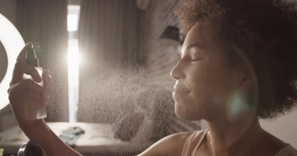 Blij Afro Amerikaanse Vrouwelijke Hydraterende Gezicht Met Spray Thuis — Stockvideo