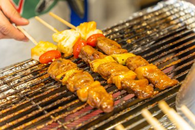 Izgarada barbekü şişi, kebap ve sebze.