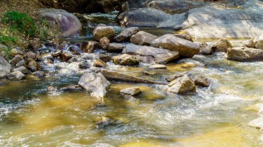 Su doğada kayalar boyunca akıyor, şelale gibi.