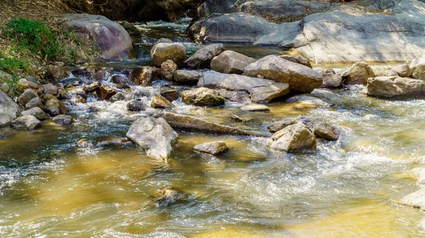 Su doğada kayalar boyunca akıyor, şelale gibi.