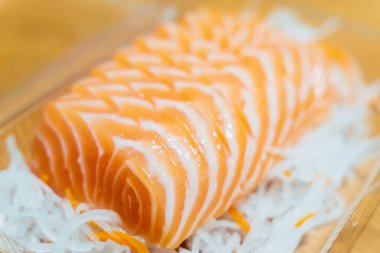 Dilimlenmiş somon balığı dilimlenmiş turpun üzerine konur..