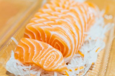 Dilimlenmiş somon balığı dilimlenmiş turpun üzerine konur..