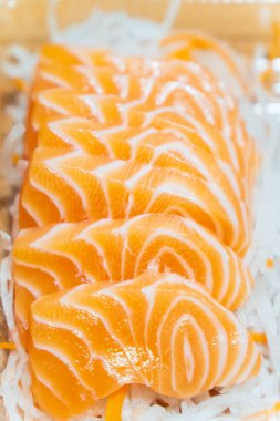 Dilimlenmiş somon balığı dilimlenmiş turpun üzerine konur..