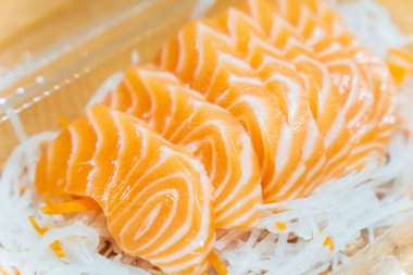 Dilimlenmiş somon balığı dilimlenmiş turpun üzerine konur..