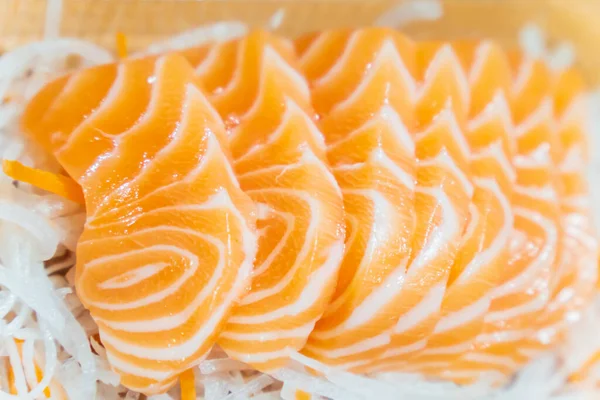 Dilimlenmiş somon balığı dilimlenmiş turpun üzerine konur..