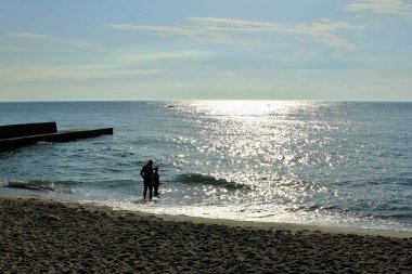 Adam sahilde yürüyor.