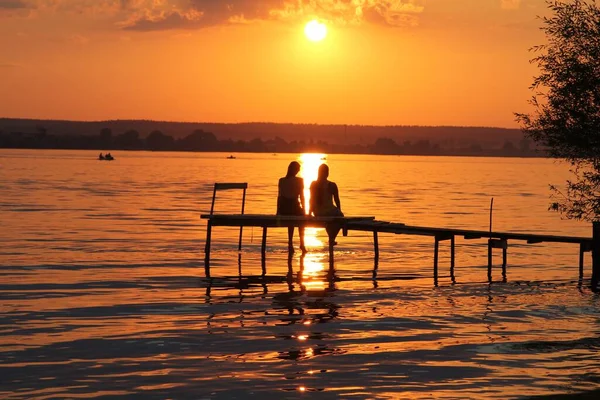 Σιλουέτα Του Νεαρού Ζευγαριού Στο Ηλιοβασίλεμα Πάνω Από Λίμνη Όμορφο Φωτογραφία Αρχείου