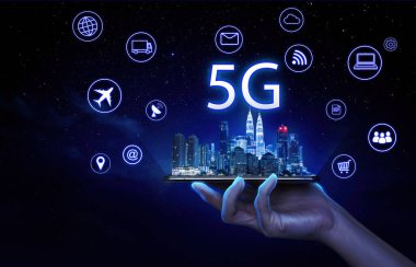Akıllı şehir Kuala Lumpur ve 5G ağ kablosuz sistemleri ve sanal ekranda bazı şeylerin interneti olan bir cep telefonu tutan iş adamı