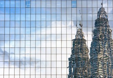 KUALA LUMPUR, MALAYSIA - 20 AĞUSTOS 2019 Petronas İkiz Kuleleri 'nin mavi cam kuleler üzerine yansımaları