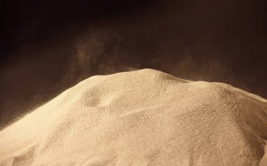 Kum tepeciklerinin üzerinden esen kum manzarasını kapat 