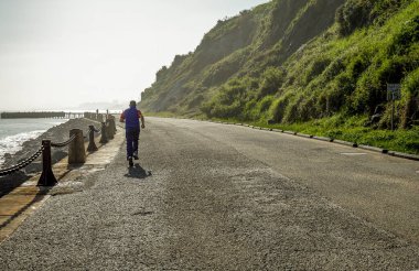 Sabahın köründe deniz kenarında koşuyor. 