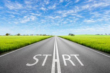 Güneşli bir günde boş bir asfalt yolda cennet bahçelerinde araba sürmek. İşaret başlangıcı ve mavi gökyüzüne doğru ok olan yeni bir başlangıç görüşünü kavra