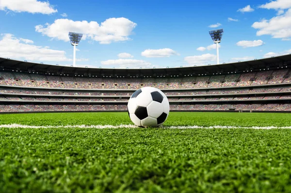 Soccer ball / football on field in stadium with fans before the match