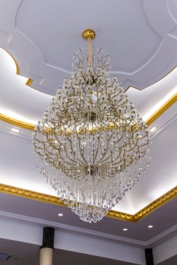 Büyük kristal avize ve duvarda beyaz ışık.