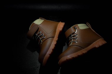 Çocuğun deri botları siyah arka planda izole, kapalı çocuk eğitimi için çok havalı görünüyor.