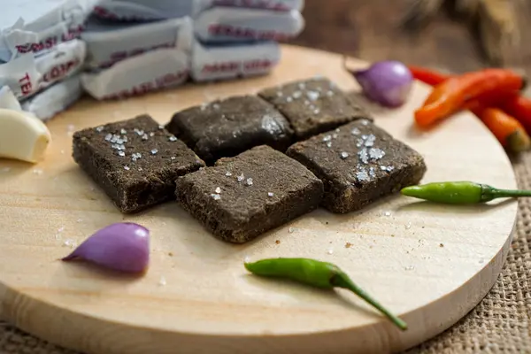 Terasi, acı biber sosu ve ahşap tabakta yiyecekler.