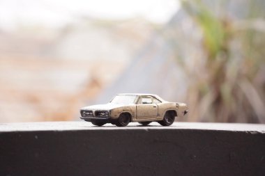 Beton platformda arka planı bulanık sarı paslı araba oyuncakları.