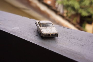 Beton platformda arka planı bulanık sarı paslı araba oyuncakları.