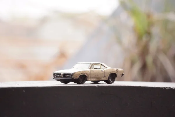 Beton platformda arka planı bulanık sarı paslı araba oyuncakları.