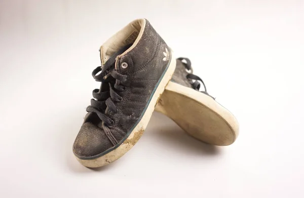 Eski kirli Adidas çocukları beyaz arka planda tuval gibi ayakkabılar.