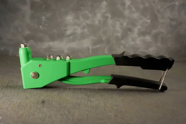 Beton arka planı olan perçin pense.