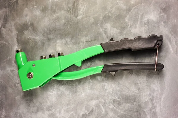 Beton arka planı olan perçin pense.