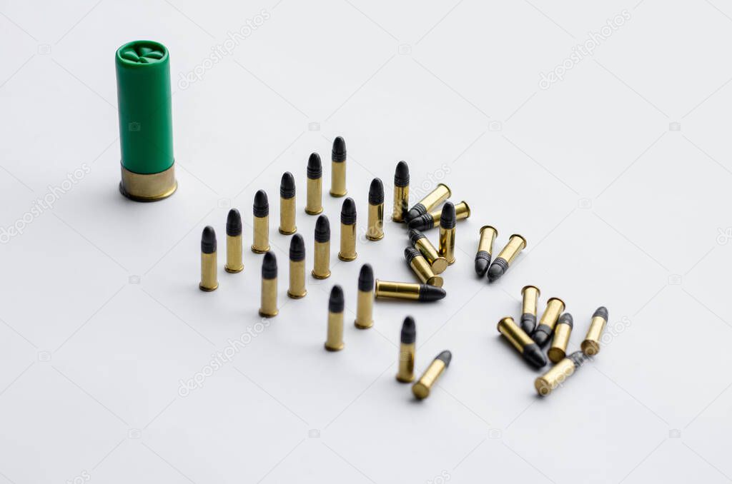 same caliber bullets near shotgun shell on white 