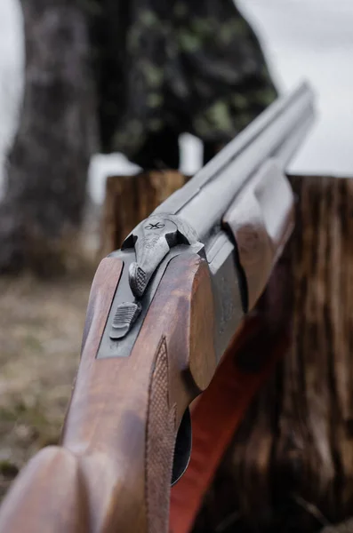 Close up of military shotgun on stump with blurred background — Stock Photo