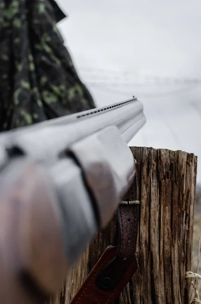 Close up of military shotgun on stump with blurred foreground — Stock Photo