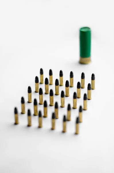 High angle view of bullets near blurred shotgun shell on white background — Stock Photo