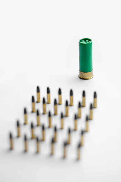Vue en angle élevé de balles floues près de la cartouche de fusil de chasse sur fond blanc — Photo de stock