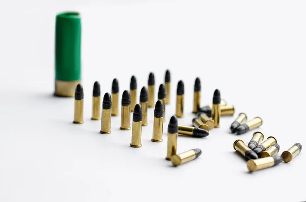 Bullets near blurred shotgun cartridge on white background — Stock Photo