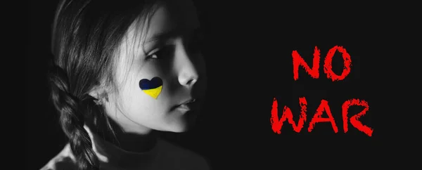 Foto monocromática de menina frustrada com bandeira ucraniana pintada na bochecha perto de nenhuma guerra lettering em preto, banner — Fotografia de Stock