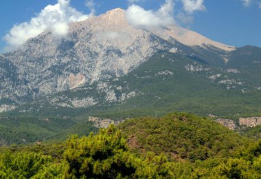 Türkiye 'nin Antalya bölgesinin Kemer ilçesi yakınlarındaki bulutlar tarafından biraz karartılmış Tahtali Dağı manzarası