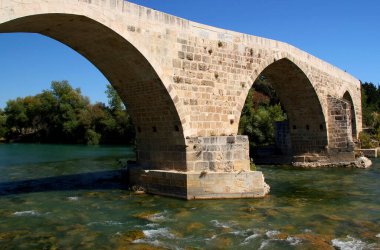 Türkiye 'nin Antalya kenti yakınlarındaki güzel taş kemerli Tarihi Aspendos Köprüsü
