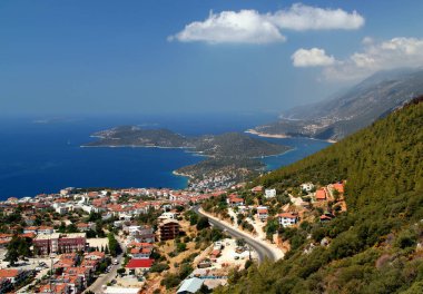 Akdeniz kıyılarının panoramik manzarası, dağlar ve bulutlar, Türkiye 'nin Antalya bölgesinin Kas ilçesi yakınlarındaki adalara benzemek üzere siluete bürünmüş
