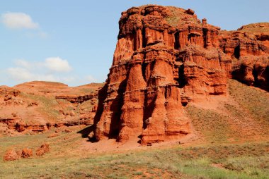 Türkiye 'nin Doğu Anadolu bölgesindeki Erzurum kenti yakınlarında, bulutlu mavi gökyüzüne karşı erozyon ve havadan oluşan kızıl dağlı Narman Peribacalari manzarası