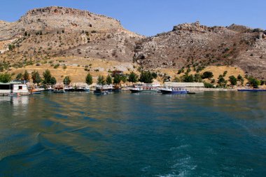 Güneydoğu Türkiye 'nin Halfeti kentinin tarihi kesiminde dağlar, Fırat nehri ve demirlemiş teknelerle manzara