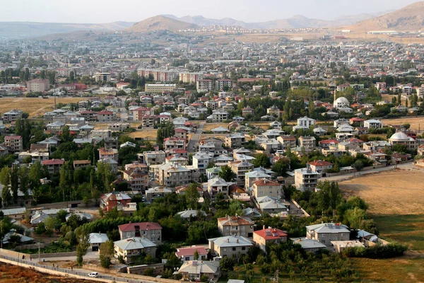 Türkiye 'nin Doğu Anadolu bölgesindeki dağların arka planına karşı Van kentinin panoramik bir görüntüsü