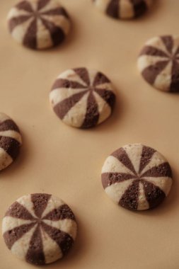 Bej arka planda yuvarlak çikolatalı sarmal kurabiyeler.