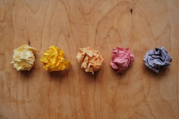 Buruşmuş renkli kağıttan bir top tahtanın üzerinde gül şeklinde.